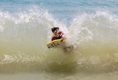 My son bodyboarding, gets hit by a wave returning from sh... by Helen Brierley 