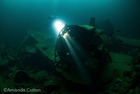 Diver shines his light through a Zero Fighter Plane insid... by Amanda Cotton 