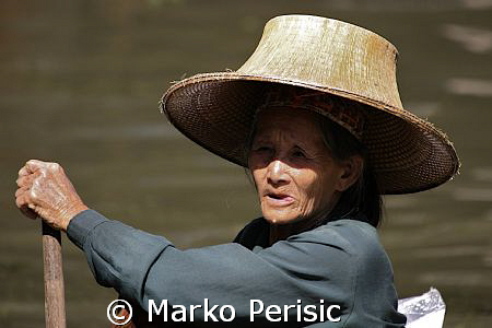 Portrait of a fisher woman making her way in a dug out boat. by Marko Perisic 