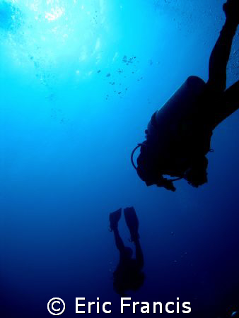 divers going into the abyss at the dropoff sipadan by Eric Francis 