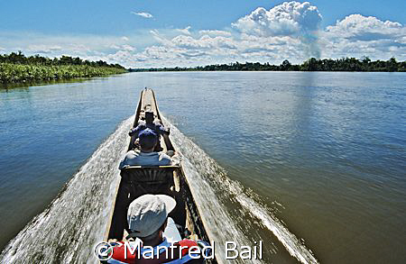 crousing the sepic river in a doughout... by Manfred Bail 