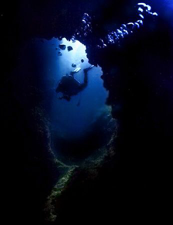 Descending through the chimney at Sail Rock, Gulf of Thai... by Soren Egeberg 