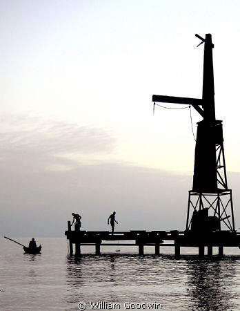 Locals fishing from the remains of the Pirates of the Car... by William Goodwin 