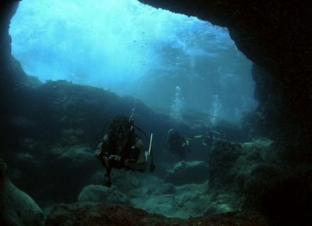 A couple of friends entering a cave. by Juan Torres 