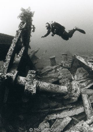 At a depth of 90 feet, a diver investigates the steering ... by Michael Grebler 
