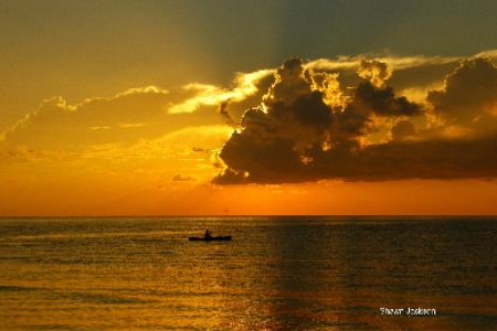 sunrise and a fisherman paddling out hoping for a good ca... by Shawn Jackson 