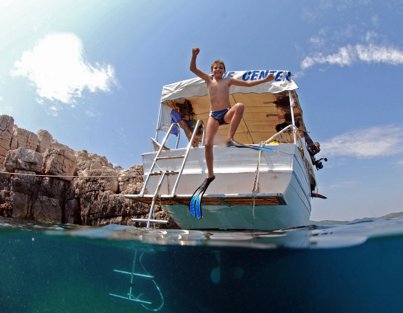 kid jumping from the boat by Andy Kutsch 