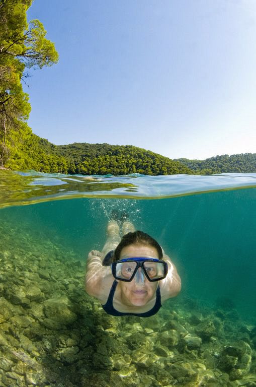 A split level shot of a swimmer enjoying the coastal wate... by Paul Colley 