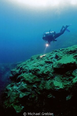 A diver approaches the crest of the vertical drop in Morr... by Michael Grebler 