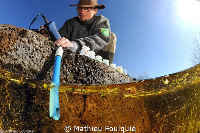scientist working in a pond by Mathieu Foulquié 