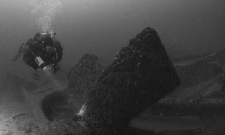 At about 140 feet, a diver hovers above the prop of the S... by Michael Grebler 