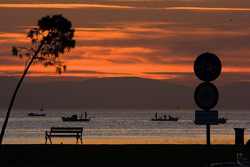 Sunset at the bay of Izmir with some fishermen heading ho... by Rico Besserdich 