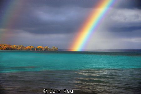 Just shot this Rainbow over Torch Lake. An inland lake in... by John Peal 