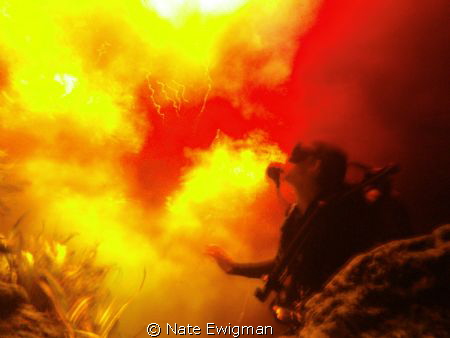 Diver looking up at tannic river waters mixing with sprin... by Nate Ewigman 