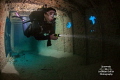 A diver models for me inside the Prince Albert shipwreck in Roatan, Honduras.  I attached a strobe to the back of her tank and had her hold a Triggerfish sensor to make the strobe fire behind her, lighting up the background. 