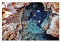 Cave diver passing through the keyhole rock formation in Ginnie Springs. Nikonos V, twin SB105 strobes, 15mm lens, 100ASA film on manual exposure. Colour corrected in PS. 