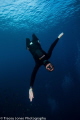 Free diver falling towards the camera with open arms