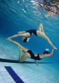 Connected. Synchro swimmers in a pool.