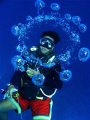 This was taken with my old Canon A70 during our safety stop at Saies Corner, Palau.  My divemaster friend was blowing bubble rings, and this particular ring perfectly framed him