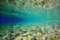 There is a thermocline on the RHS. It gets deeper on the left side as you can see from the blue color.
The sea is almost flat, just some ripples which creates a nice wavy reflection of the stones at the surface of the water