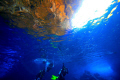 A Nice Golden Sunset glowing the Cave Rocks above the Surface, as waiting Divers Stop to Decompress after their Deep Ocean Dive at the GROTTO ion the island of SAIPAN.
